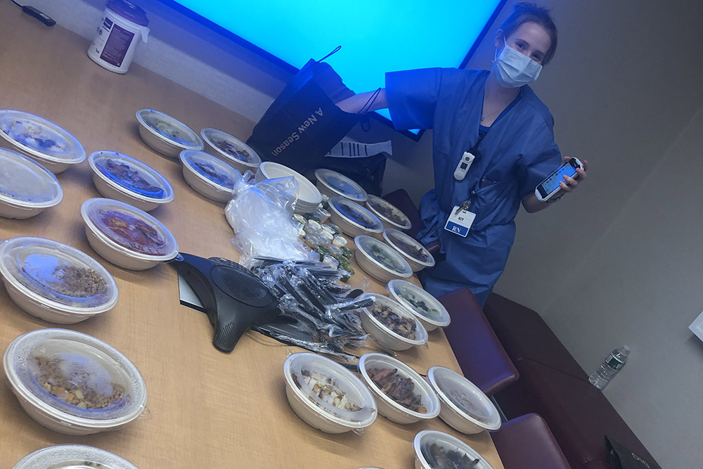 UVA nursing grad Cate Rhangos (BSN `19) with food in conference room during 2020 COVID-19 pandemic
