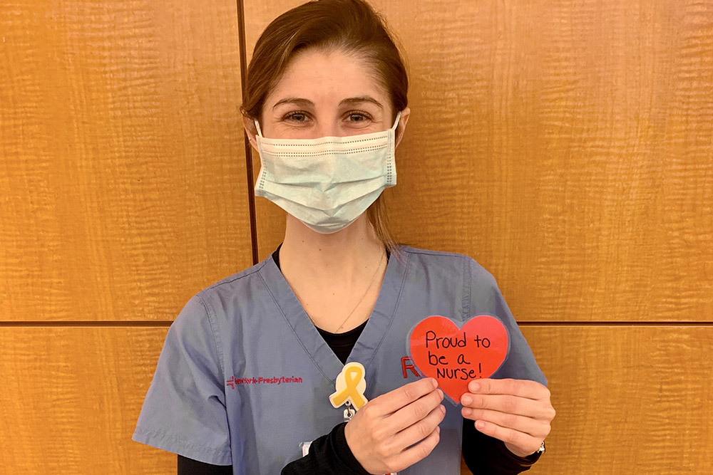 UVA Nursing graduate Lauren Dickinson (BSN `19) holding heart-shaped sign during 2020 COVID-19 pandemic. Proud to be a nurse.