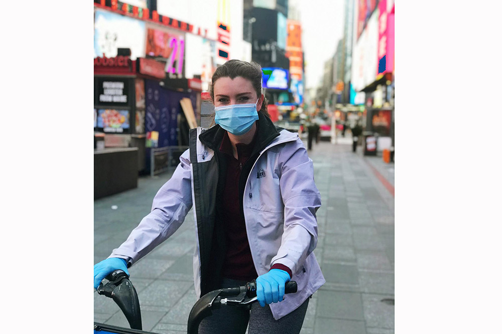 Elise Bottimore Talbot, BSN 16, is a COVID nurse in NYC, in Times Square on a bike.