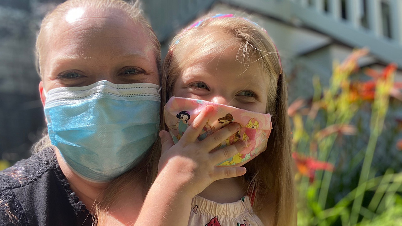 DNP grad and ER nurse Lizze Lawwill with daughter Madeline, both wearing face masks
