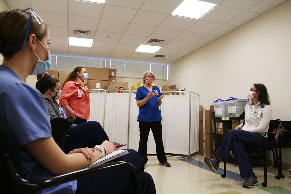 prof Emma Mitchell and clinical instructors Sharon Veith and Cat Elmore teach BSN students at a vaccine clinic simulation.