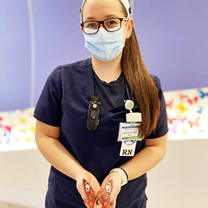 BSN graduate Talia Sion, a labor and delivery nurse in New Jersey holding a butterfly, which represents the births that've taken place at St. Barnabis Hospital.