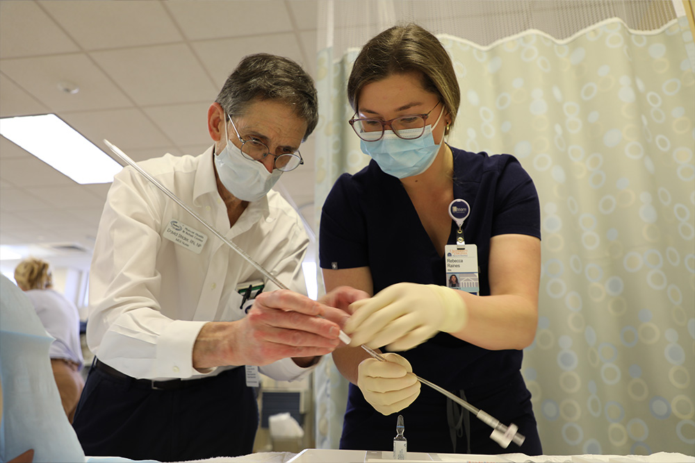 An APRN student works with David Strider, instructor