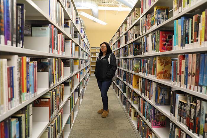 Diana Hernandez, RN to BSN student and INOVA cardiovascular nurse, in the Burke Public Library where she studies.