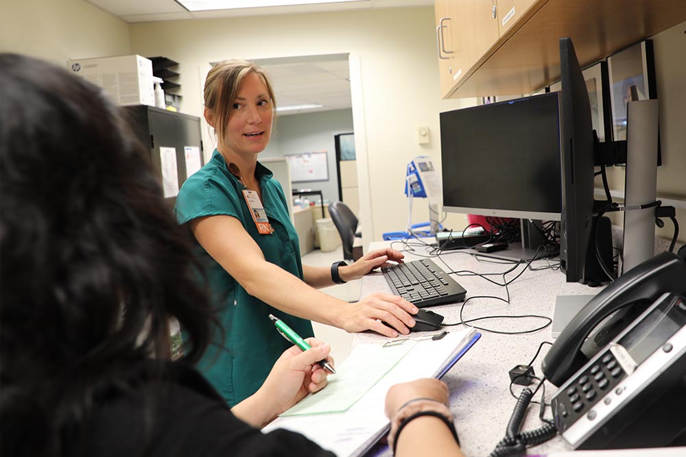 DNp and CNL grad May Gallanosa talks with nurse Stanley