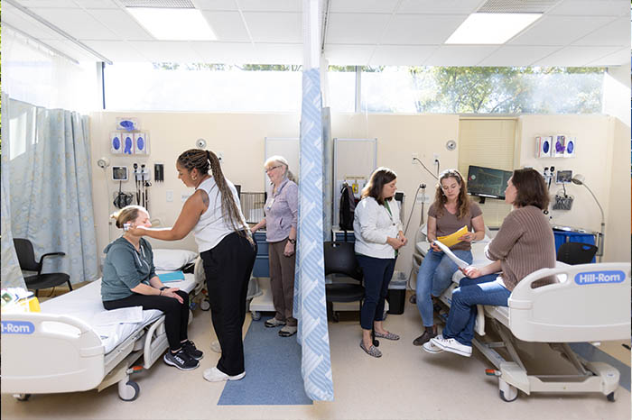 Advanced practice nursing students practice in a lab.