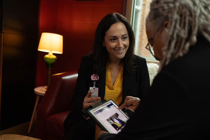 Meghan Mattos shows a patient an insomnia intervention on an iPad.