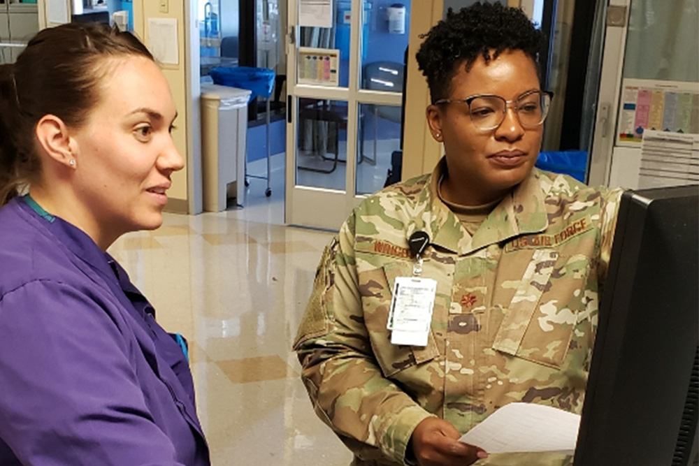 Air Force Major Q Wright and colleague discuss Wright's new social needs screening tool.