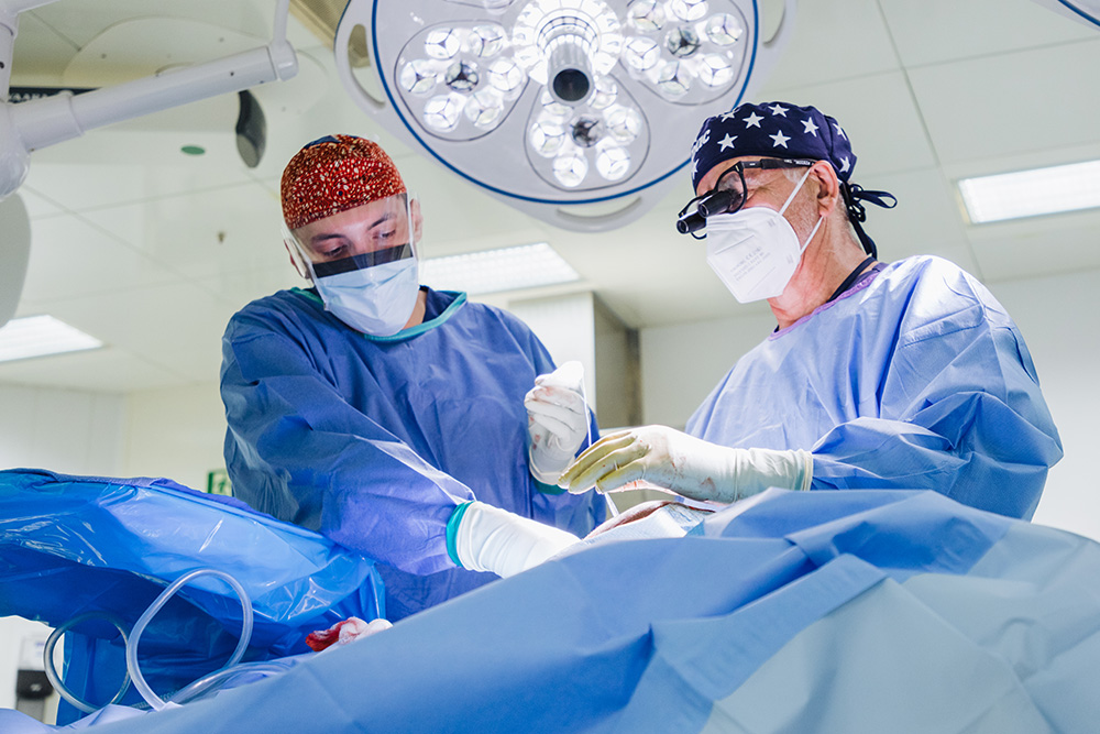OR nurse and CNL alumnus Seth McElroy assists during a lipoma surgery.
