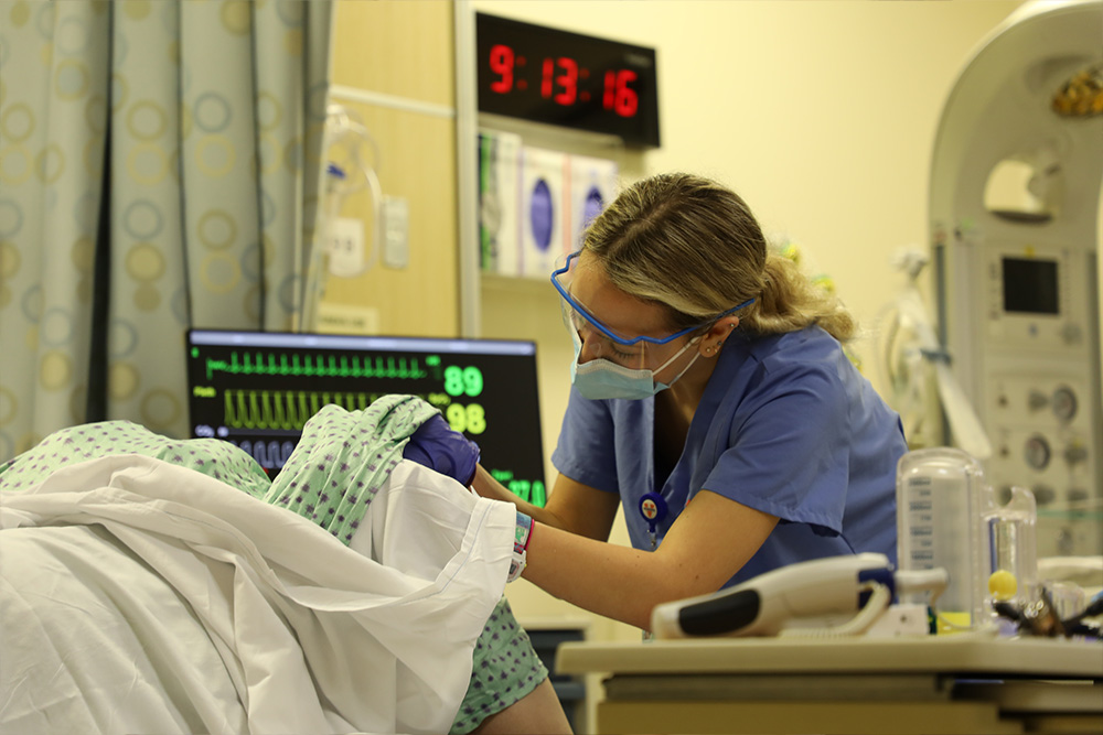 Birthing simulation - a nursing student checks the patient's cervical dilation